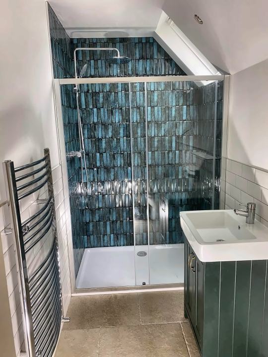 Blue tile shower with green vanity