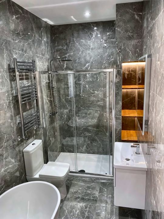 Grey marble bathroom with lit niches