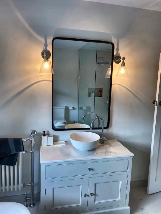 Vanity with vessel basin and wall lights